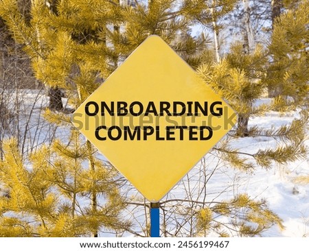 Onboarding completed symbol. Concept words Onboarding completed on beautiful yellow road sign. Beautiful forest snow blue sky background. Business onboarding completed concept. Copy space.