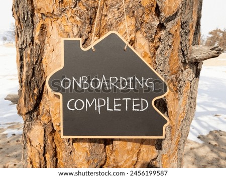 Onboarding completed symbol. Concept words Onboarding completed on beautiful black house blackboard. Beautiful tree background. Business onboarding completed concept. Copy space.