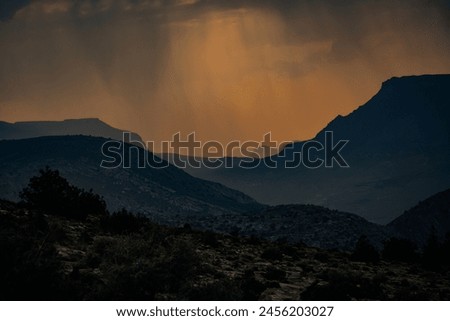 A beautiful picture of the mountain top that is cover in light rain, the sunset in the background sets up beautiful nature scenery. it is a true representation of nature's colors at the same time. 