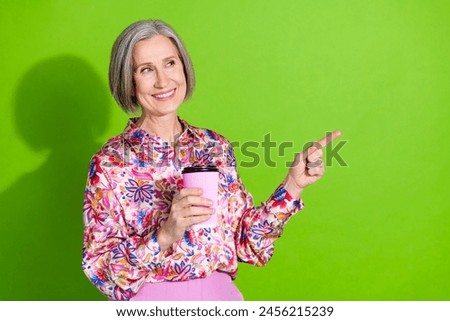 Photo of cheerful sweet lady pink shirt drinking tea showing empty space isolated green color background