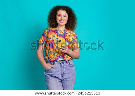 Photo of cheerful pretty woman wear stylish print clothes hold device isolated on cyan color background