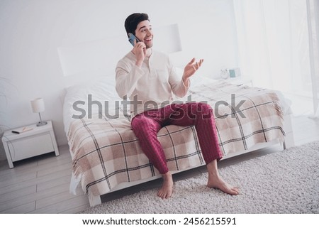 Photo of positive attractive man speaking phone on weekend morning cozy apartment white day light interior indoors Royalty-Free Stock Photo #2456215591