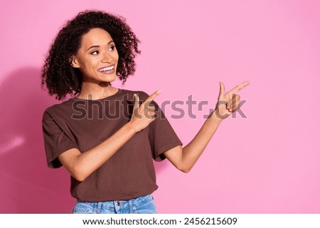 Photo of nice young girl point fingers empty space ad wear brown t-shirt isolated on pink color background
