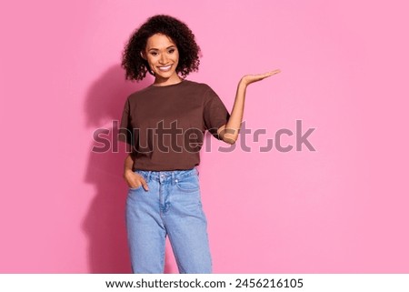 Photo of nice young girl hold empty space wear brown t-shirt isolated on pink color background