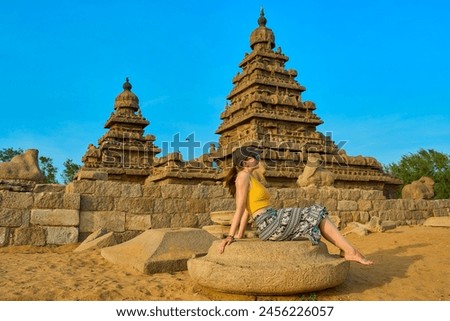 woman tourist sitting in front Mahabalipuram Shore Temple                           Royalty-Free Stock Photo #2456226057