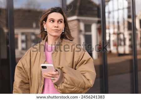 Single sad girl waiting for a phone call walking outside. Blonde woman with short hair look unhappy, waiting for answer from her boyfriend. Royalty-Free Stock Photo #2456241383