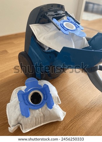 replacing the dirt and dust bag in a vacuum cleaner Royalty-Free Stock Photo #2456250333