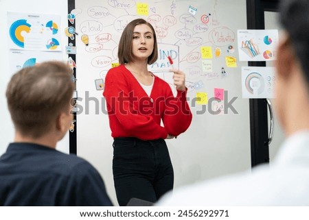 Professional attractive female leader presents creative marketing plan by using brainstorming mind mapping statistic graph and colorful sticky note at modern business meeting room. Immaculate. Royalty-Free Stock Photo #2456292971
