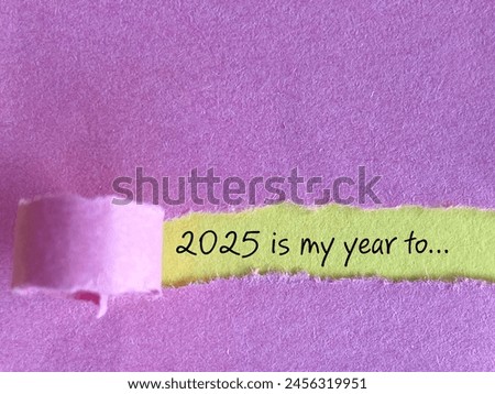 2025 the year with plans and resolutions behind torn paper background. Stock photo.