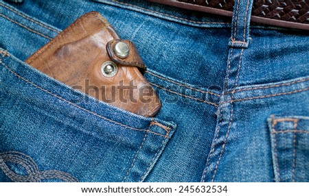 closeup photo of an old leather wallet in a jeans pocket