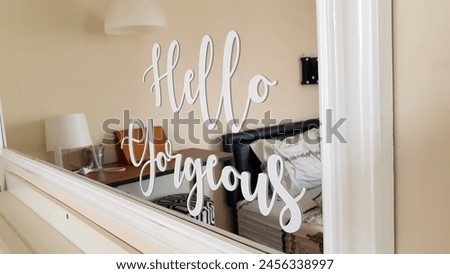 HELLO GORGEOUS mirror cutting sticker with blurred background of the bedroom interior. Typography quote of self love, self care, self appreciation. Positive, health, beauty and wellness concept.