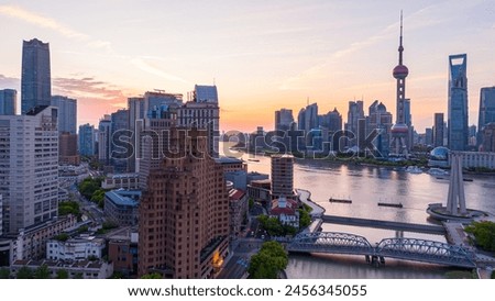 Aerial view of modern city skyline and buildings at sunrise in Shanghai.