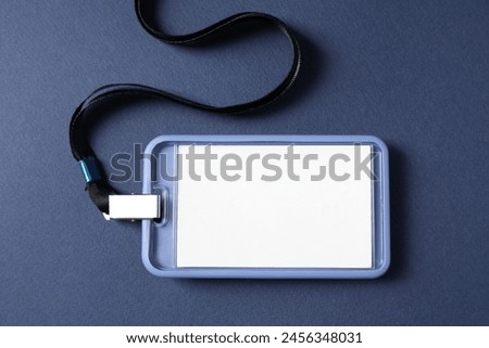 Blank badge with string on blue background, top view