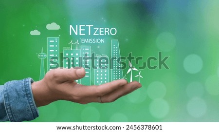 Net zero carbon neutral with city, wind turbines, solar panels, and recycling icons concept, reducing emission and carbon dioxide, hand copyspace green natural background.
