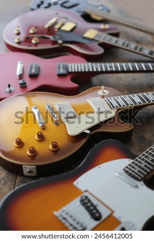 Group photo of electric guitars taken against a dark background