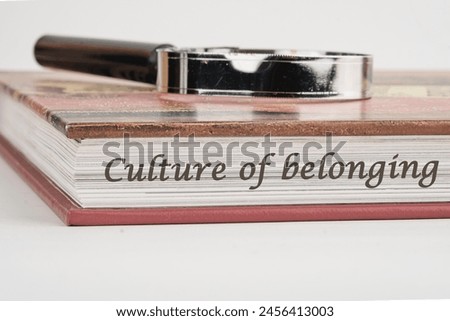 Culture of belonging symbol on a book with a magnifying glass on top on a white background