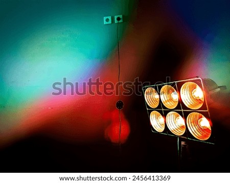 Floodlight in a dark room with colorful rays 