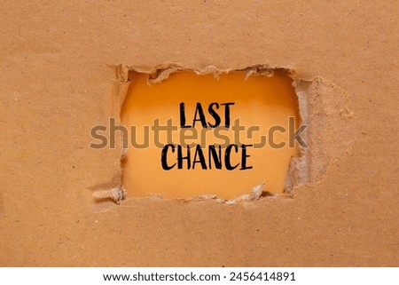 Last chance words written on ripped cardboard paper with orange background. Conceptual last chance symbol. Copy space.