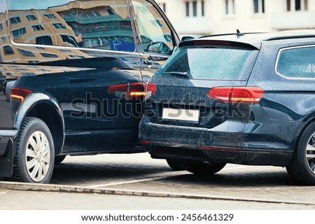 Car accident in parking lot, maneuvering unsafely in confined spaces. Parking accident due to limited visibility, distracted driving. Rear-up collision,  driver is reversing and hit parked car Royalty-Free Stock Photo #2456461329