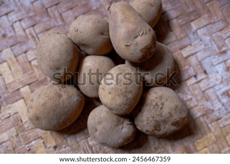 Freshly Harvested Potatoe on Woven Bamboo Tray, healthy food, stock photo. 