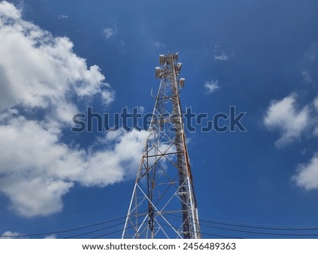 Radio communication antenna with Electrical wires passing through on  the sky background with scattered clouds. tower functions as a building to capture electromagnetic . Wireless Antenna connection. 