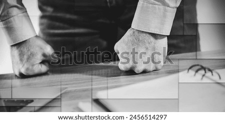 Enraged businessman banging his clenched fists on the desk, geometric pattern Royalty-Free Stock Photo #2456514297