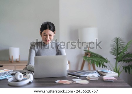 Graphic designer women typing data on laptop while working about graphic designing with technology.