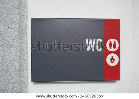 European water closet public restroom sign with symbols for gender and baby changing station