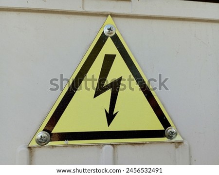Triangular lightning sign on a yellow background. High voltage warning.