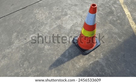Orange street cone road creating shadow middle of the day