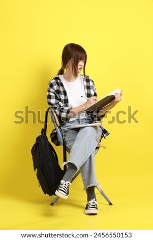 Asian college female student wearing plaid shirt carry school bag and book, gesture of sitting and studying. Studying abroad, Gen Z, E-learning.