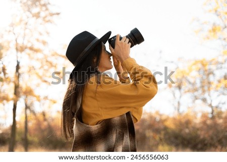 Professional woman photographer taking photo on camera outdoor, photography nature. Hobby and lifestyle Concept