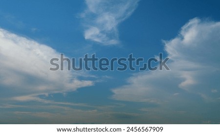Cirrostratus clouds flying slowly on beautiful blue sky horizon background. Timelapse. Royalty-Free Stock Photo #2456567909