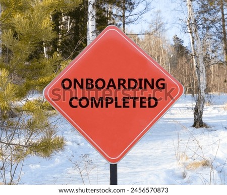 Onboarding completed symbol. Concept words Onboarding completed on beautiful red road sign. Beautiful forest snow blue sky background. Business onboarding completed concept. Copy space.