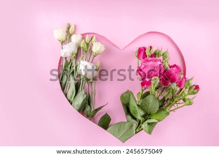 Mother's day international holiday greeting card , on pink background with flowers. Cut out heart shaped frame with rose bouquet, flat lay top view copy space