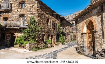 Village church with stone houses around next to the mountain, Castilla la Mancha, Spain. Royalty-Free Stock Photo #2456583145