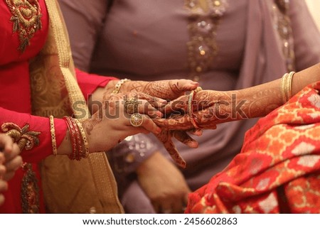 Indian wedding rituals. Indian bride getting her wedding bangles. Indian Mother helping putting bangles on bride hand Royalty-Free Stock Photo #2456602863