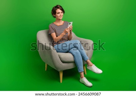 Full size portrait of lovely gorgeous girl sit cozy chair use smart phone texting isolated on green color background