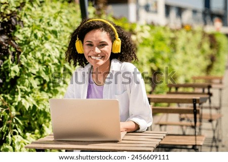 Photo of cute pretty lady wear white shirt headphones sitting cafeteria remote university studying outside urban city park