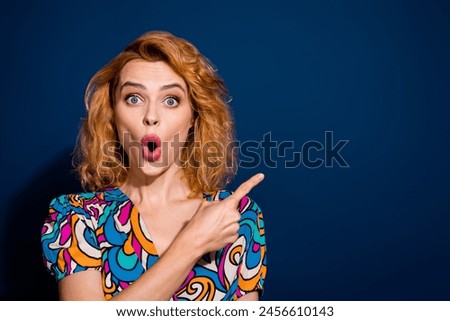 Photo of lovely astonished lady wear stylish clothes introduce billboard empty space isolated on dark blue color background