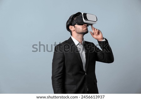 Caucasian business man planning financial plan while using VR goggle. Professional project manager standing and touching VR headset while using visual reality glasses to connect metaverse. Deviation.