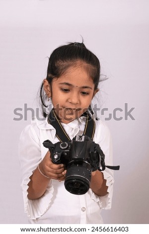 Cute Indian Photographer with camera.  Junior little girl with camera. Indian creative kid visual.