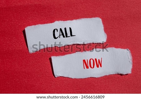 Call now words written on ripped white paper pieces with red background. Conceptual call now symbol. Copy space.