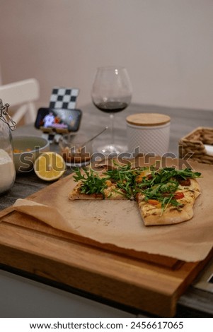 Pizza, movie evening, red wine, lemon, recipe, homemade pizza, cheese, sauce, salami, cherry tomato Royalty-Free Stock Photo #2456617065