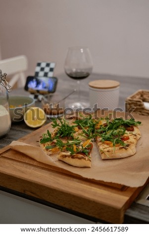 Pizza, movie evening, red wine, lemon, recipe, homemade pizza, cheese, sauce, salami, cherry tomatos Royalty-Free Stock Photo #2456617589