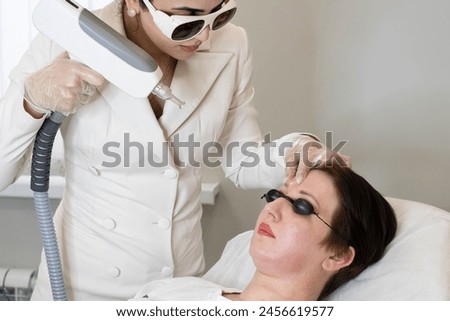 High-tech skincare session underway, focus on patient experience. Highlights the personalized approach in modern beauty regimes. Royalty-Free Stock Photo #2456619577