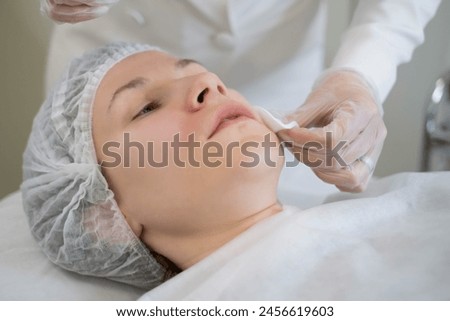 The cosmetologist's precise handwork preps for facial treatment. This step is vital for the success of cosmetic enhancements.