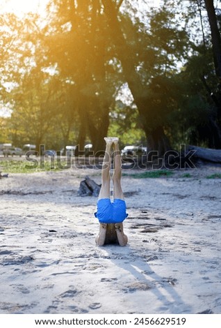 Young caucasian sportsman with fit strong body practicing yoga on the sandy beach next to the pine forest at sunrise on summer, barefoot in training wellbeing and healthy lifestyle concept.Vertical.