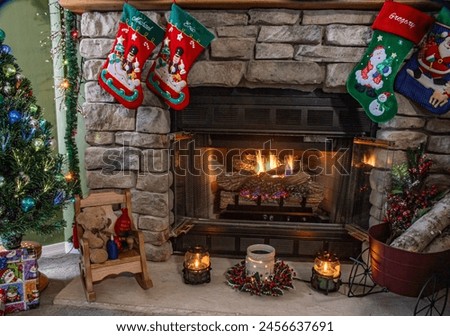 A fireplace with a red and green stocking hanging from it. The stocking is decorated with a santa and a snowman