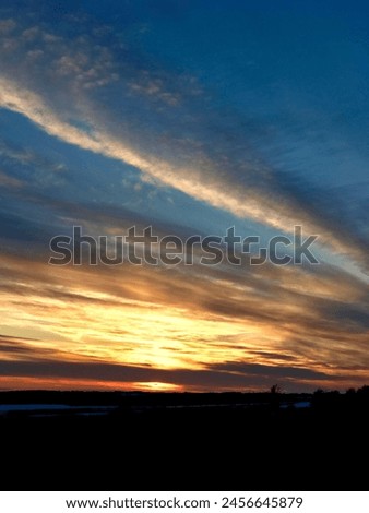 Amazing winter sky sunset twilight. Dusk night fall gloaming. Landscape silhouette horizon. Cloud formations undersides colored coloured. Blue black orange yellow gold. Beauty in nature. Striking.